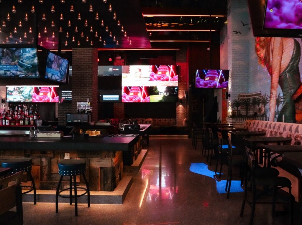 upscale sports bar with large TV screens and ambient lighting.