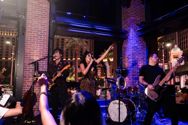 Singer and band performing live at indoor venue with audience