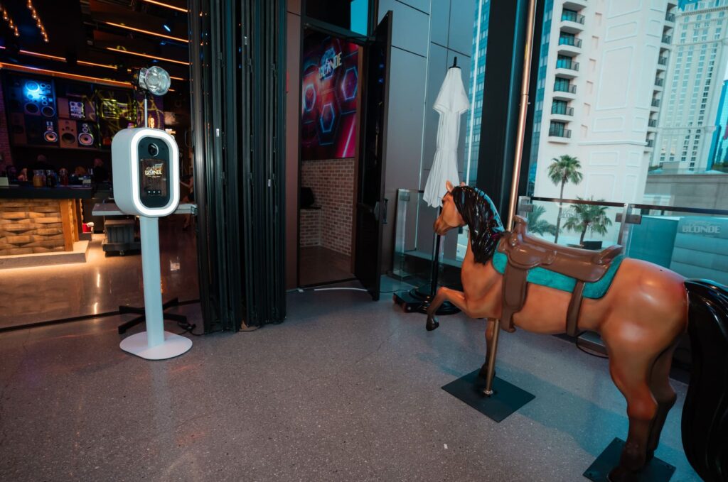 Bottled Blonde photo booth and horse statue near the venues glass wall