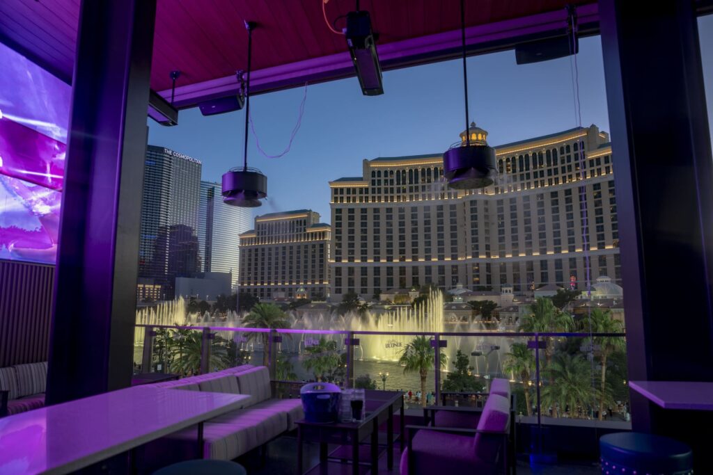 Lounge seating on a rooftop patio overlooking the Bellagio fountains and Las Vegas skyline
