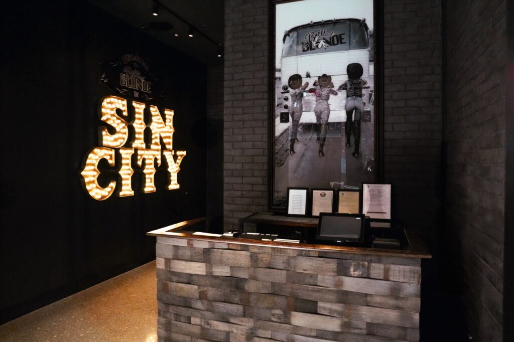 Rustic style hostess stand with large SIN CITY sign and vintage photo