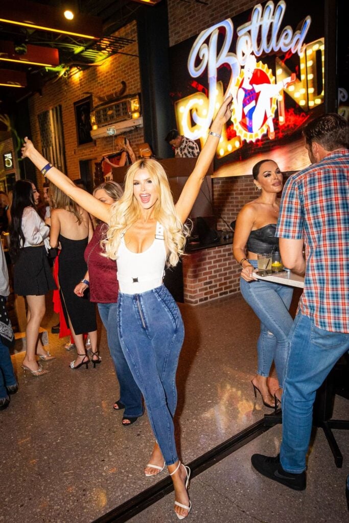 Woman with raised arms celebrating at Bottled Blonde Las Vegas