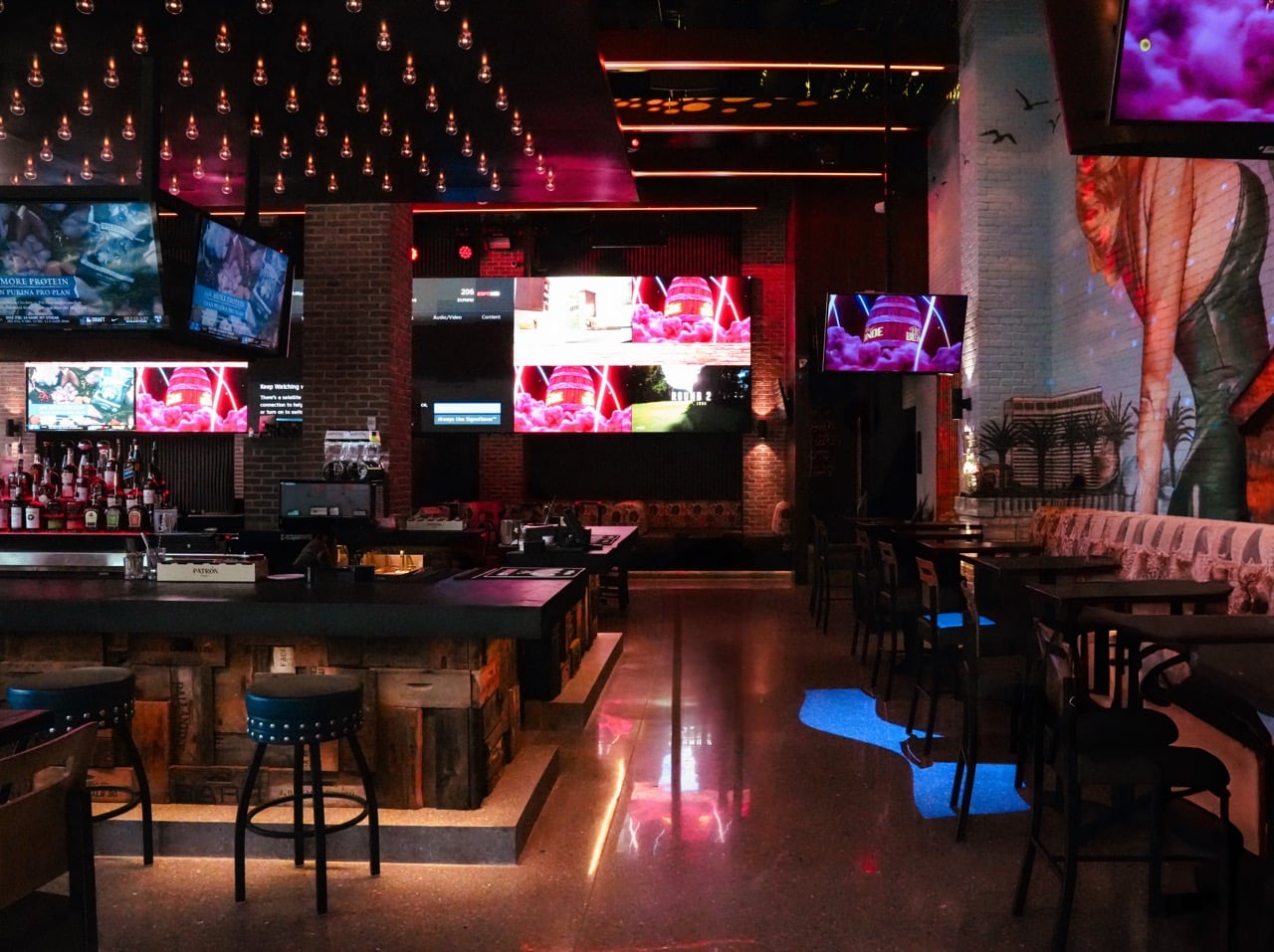 upscale sports bar with large TV screens and ambient lighting.