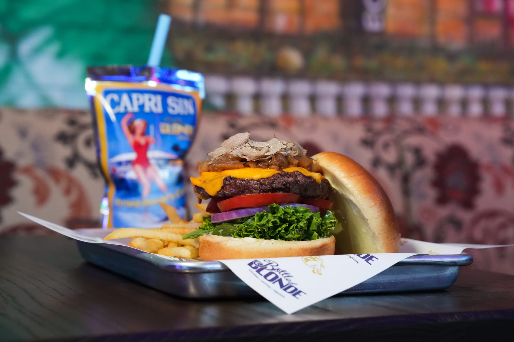 Cheeseburger with fries served on a tray with a Capri Sun-inspired drink pouch