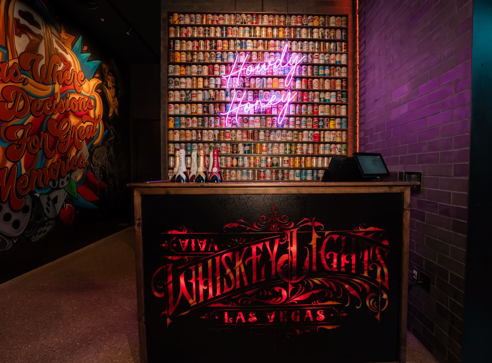 Whiskey Lights Las Vegas bar with neon "Howdy Honey" sign and vintage can display.