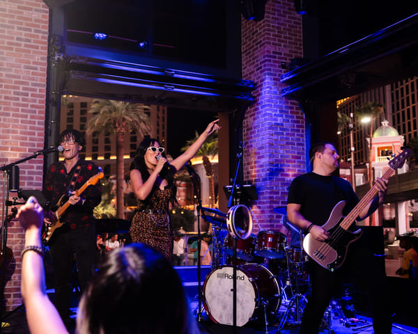 Singer and band performing live at indoor venue with audience