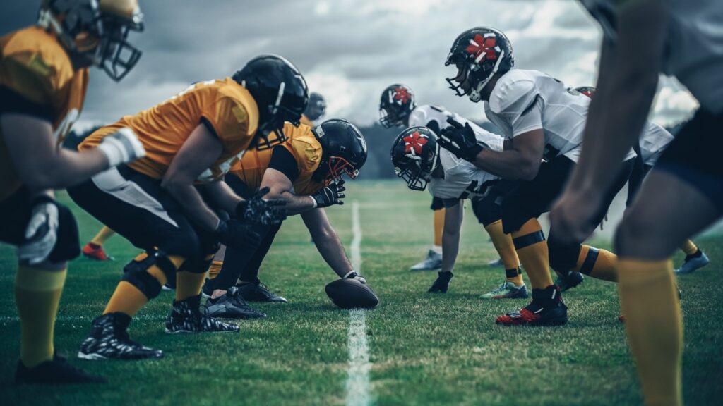 American football teams lined up at the line of scrimmage during a game