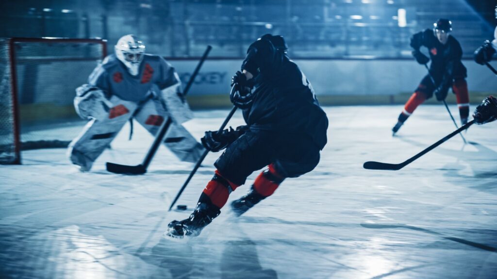 Ice hockey players in action during a game with a goalie defending the net